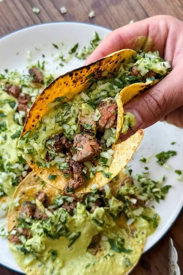 Grilled steak tacos with avocado salsa served on a plate
