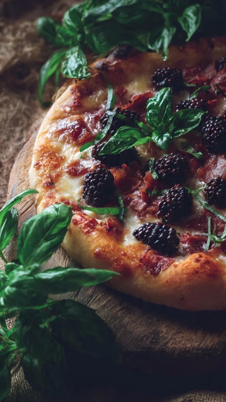 Grilled Blackberry Bacon Basil Pizza topped with fresh basil leaves and blackberries