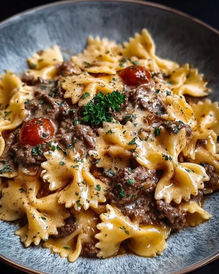 Creamy beef pasta dish garnished with herbs and cheese